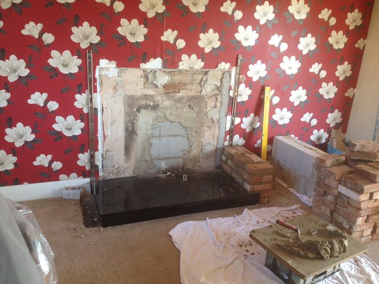 A picture of a fireplace being renovated