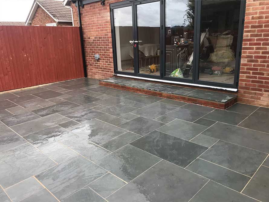 A picture of a newly laid patio with grey slanted slabs